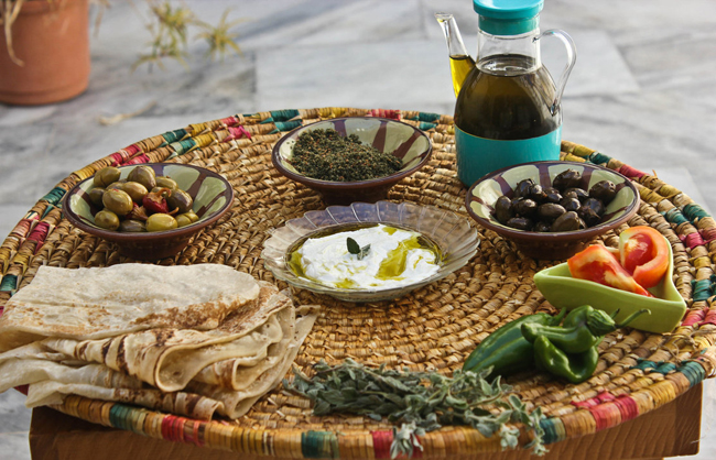 A traditional Palestinian meal featuring olive oil, olives, bread, and local dishes that reflect the rich culinary heritage of Palestine.